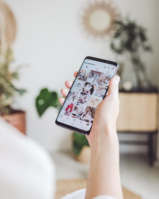 Woman's hand holding a smartphone with Instagram loaded