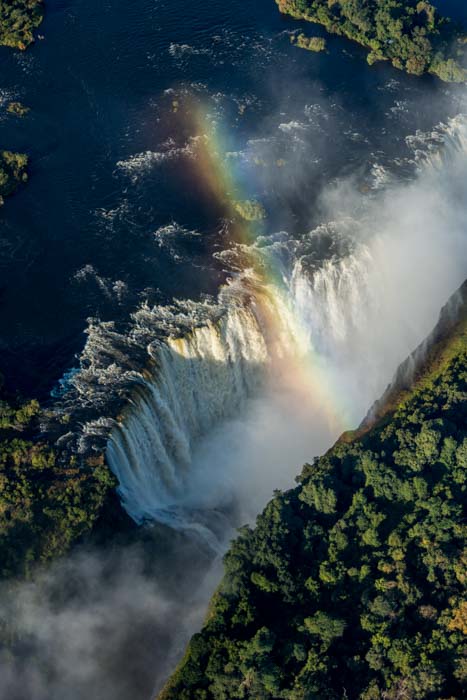 Overhead shot of a small rainbow over Victoria Falls and some foliage